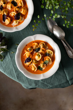 tomato soup with cappelletti pasta, cream and basilの写真素材