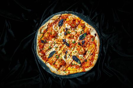 Tasty pizza on black background. Top view of hot pizza.の写真素材