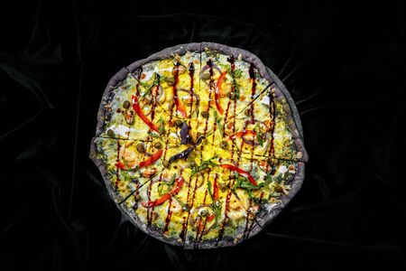 Tasty pizza on black background. Top view of hot pizza.の写真素材