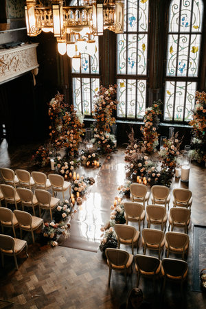 An elegantly decorated indoor wedding venue featuring floral arrangements, stained glass windows, and sophisticated seating, creating a romantic atmosphere for a memorable ceremony.の写真素材