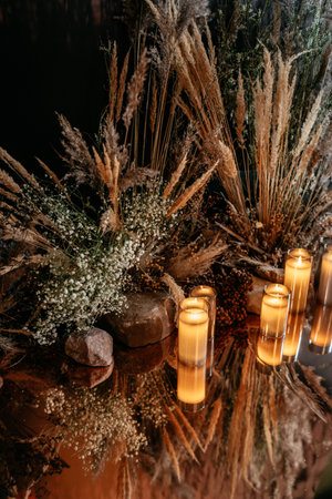 Warm candlelight illuminating dried flowers creates a serene and elegant ambiance, reflecting harmony and nature-inspired decor in a tranquil setting.の写真素材