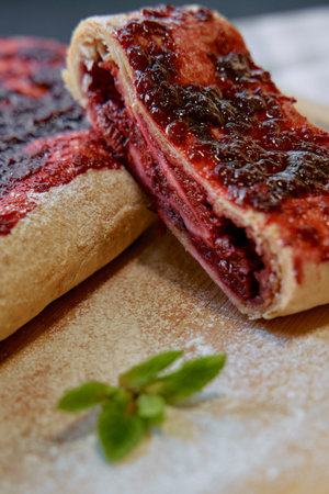 Delicious Homemade Berry Jam Roll with Flaky Dough and a Touch of Powdered Sugar, Perfect for...