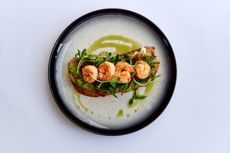 Deliciously Crafted Avocado Toast Topped with Succulent Shrimp and Fresh Microgreens, Drizzled with Tangy Dressing on a Stylish Plateの写真素材