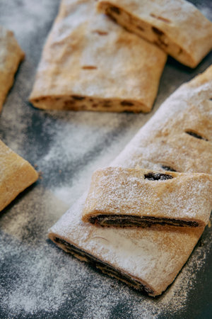 Freshly Baked Pastry Rolls with Sweet Filling and Dusting of Powdered Sugar on a Rustic Surface, Perfect for Dessert or Snack Momentsの写真素材