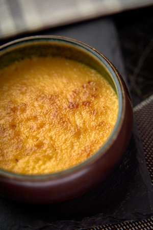 A Close-Up View of a Creamy and Golden CrÃ¨me BrÃ»lÃ©e Dessert, Showcasing its Silky Texture...