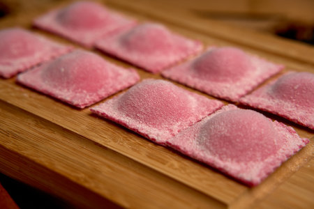 Handmade Pink Ravioli on a Wooden Board Ready for Cooking, Showcasing the Freshness and Artistry of Italian Culinary Traditionの写真素材