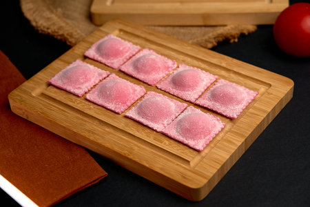 Delightful Pink Ravioli Arrangement on a Wooden Board Ready for Cooking or Serving, Showcasing Their Unique Color and Textural Appeal in a Culinary Presentationの写真素材