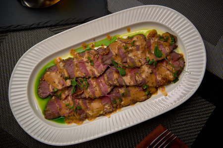 Succulent Roast Beef Served on a Decorative Platter with Rich Gravy and Fresh Garnish Ideal for Gourmet Dining Experiencesの写真素材