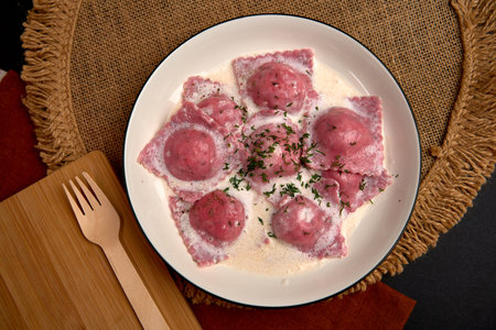 Delicious Handmade Ravioli on a Plate Garnished with Creamy Sauce and Herbs that Highlight the Colorful Presentation of the Dishの写真素材