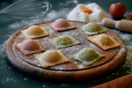 A Colorful Array of Fresh, Homemade Ravioli Filled with Rich Ingredients, Perfectly Placed on a Wooden Board Surrounded by Kitchen Essentials and Flour.の写真素材