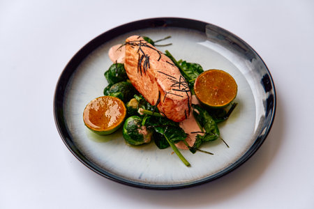 Deliciously Cooked Salmon Served with Fresh Spinach and Citrus Garnish for a Healthy and Flavorful Mealの写真素材