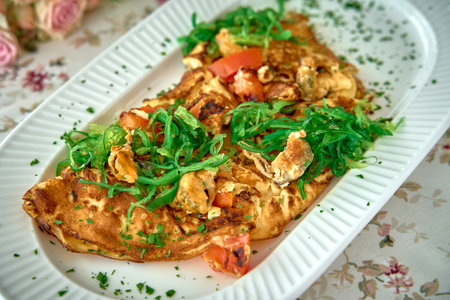 Deliciously Savory Omelette Garnished with Fresh Herbs and Vegetables, Perfectly Cooked for a Wholesome Meal Experienceの写真素材