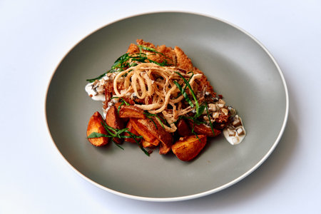 A Delicious Plate Featuring Crispy Chicken, Seasoned Potatoes, and Fresh Herbs, Elegantly Presented...