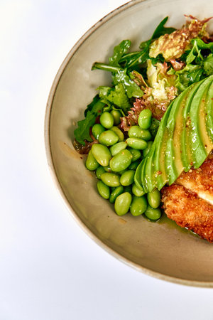 Delicious Bowl Featuring Crispy Chicken, Fresh Greens, Edamame, and Creamy Avocado for a Nutrient-Packed Meal Perfect for Health Enthusiastsの写真素材