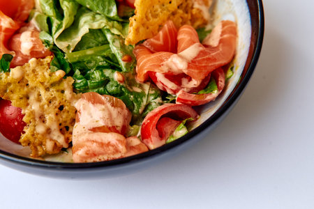 A Colorful Salad Bowl Featuring Fresh Greens, Tomatoes, Salmon, and Crispy Chips Topped with Creamy Dressing for a Delicious Meal Experienceの写真素材