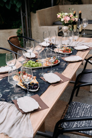 Elegant Outdoor Dining Setup with Beautiful Table Arrangements Featuring Wine Glasses, Gourmet...