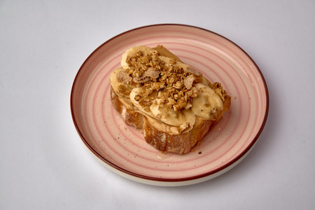Delicious Toast Topped with Sliced Bananas, Creamy Peanut Butter, and Crunchy Granola on a Stylish...
