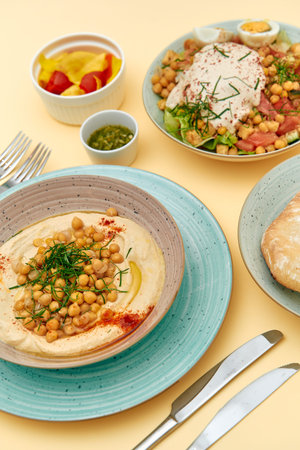 A Vibrant Display of Delicious Middle Eastern Dishes Featuring Creamy Hummus Topped with Chickpeas...