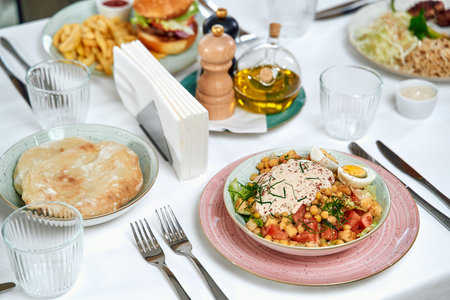 A Delicious Array of Dishes on a Dining Table Featuring Fresh Ingredients, Garnishes, and...