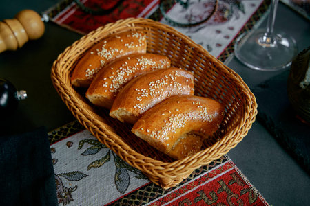Deliciously Warm Basket of Freshly Baked Pastries with Sesame Topping Served on Elegant Table...