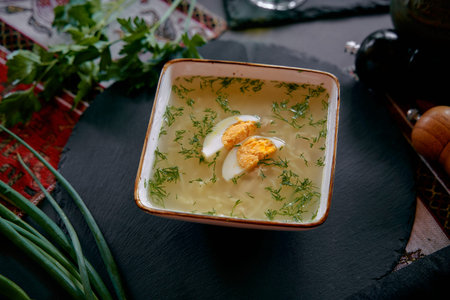 A Delicious Bowl of Freshly Prepared Soup Garnished with Herbs and an Egg, Perfect for a Cozy Meal...