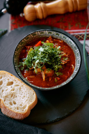 A Richly Flavored Bowl of Hearty Chili Garnished with Fresh Herbs and Accompanied by a Slice of...
