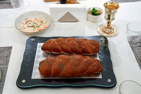 Deliciously Baked Braided Bread on a Stylish Table Setting with Accompaniments Ready for a...