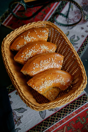 A Warm Basket of Golden-Brown Baked Goods Garnished with Sesame Seeds, Perfectly Presented for a...