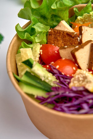 A Nutritious Salad Bowl Featuring Fresh Greens, Colorful Vegetables, Tofu, and a Hint of Sesame, Perfect for a Healthy Mealの写真素材