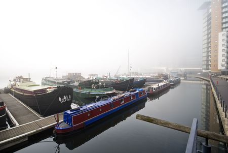 marina with houseboats in morning mist near canary wharfの写真素材