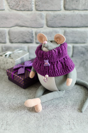 Handmade stuffed toy gray mouse symbol of the year in a knitted scarf for home decorの写真素材