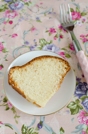 Homemade delicious cream cake on the whipped cream on the delicate pink tablecloths floweredの写真素材