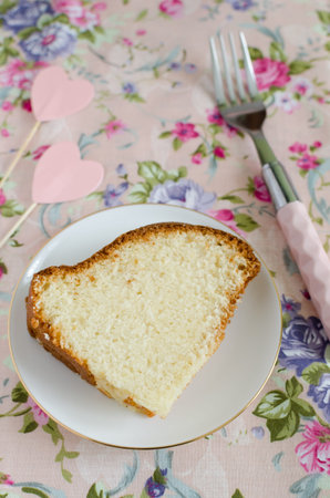 Homemade delicious cream cake on the whipped cream on the delicate pink tablecloths flowered to celebrate loversの写真素材