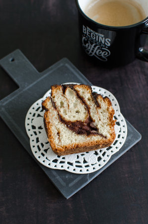 Homemade sourdough cinnamon roll and coffee on a black backgroundの写真素材