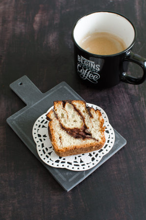 Homemade sourdough cinnamon roll and coffee on a black backgroundの写真素材