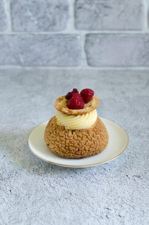 Homemade choux pastry shu with raspberry confit and lime cream on a plateの写真素材