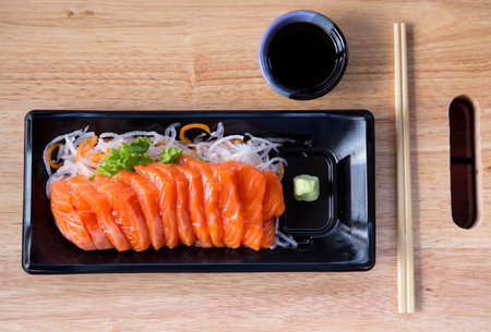 Fresh salmon and soy sauce with wasabi on dish in the wooden.の写真素材