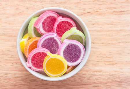 Colorful fruit jelly with sugar in cup on the wooden background.の写真素材