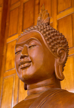 A statue of Buddha Head isolated on wooden background.の写真素材