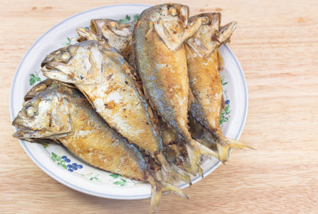 Fried mackerel fish in white dish on wood table.の写真素材