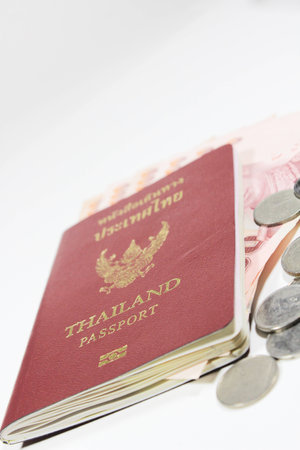 Thai passport book with money and coins isolated on white backgroundの写真素材