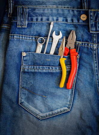 Several tools on a denim workers pocket.の写真素材