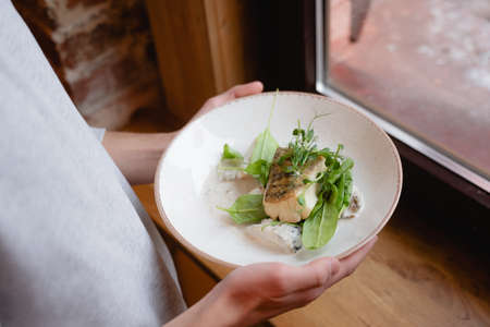 sea fish pike perch with baked potatoes and porcini mushroom sauce, beautiful restaurant serving decorated with herbsの写真素材