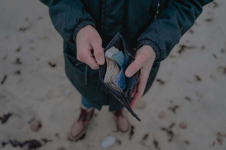 paper money in a wallet, holds in hands, savings for holidays, cash paper money for calculationの写真素材