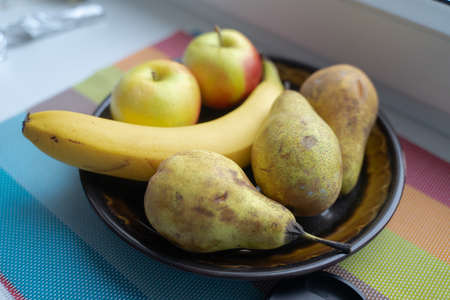 fruits lie in a cup, pears, banana and applesの写真素材