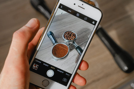 filming the process of making coffee on a mobile phone, there are two holders on the table, one with...