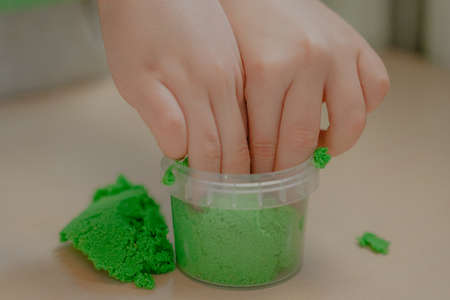 children's hands remove the toy jar, green kinetic sandの写真素材