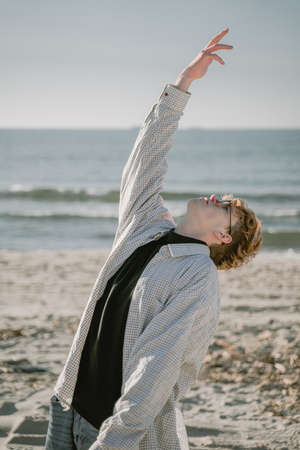 the guy turns to heaven, stretches his hand to the sky, a believer, asks for help from divine powersの写真素材