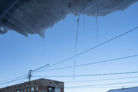 ice icicles hang from the roof, spring dropsの写真素材