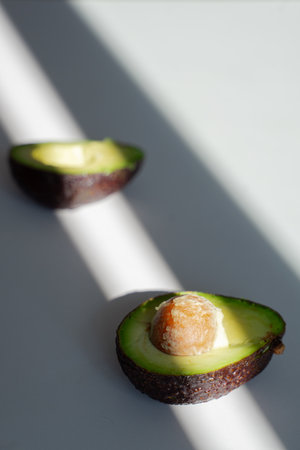 sunlight falls on the avocado lying on the tableの写真素材